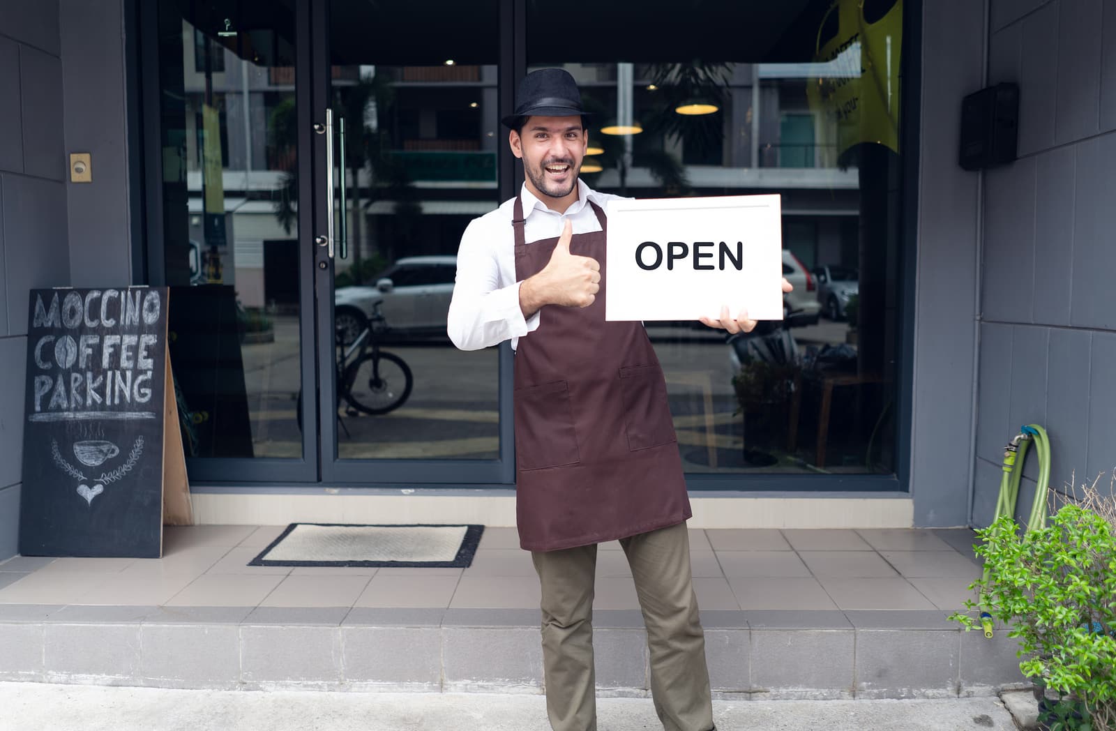 restaurant owner with OPEN sign