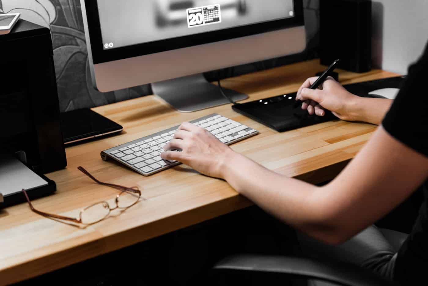 person_using_computer_on_brown_wooden_desk