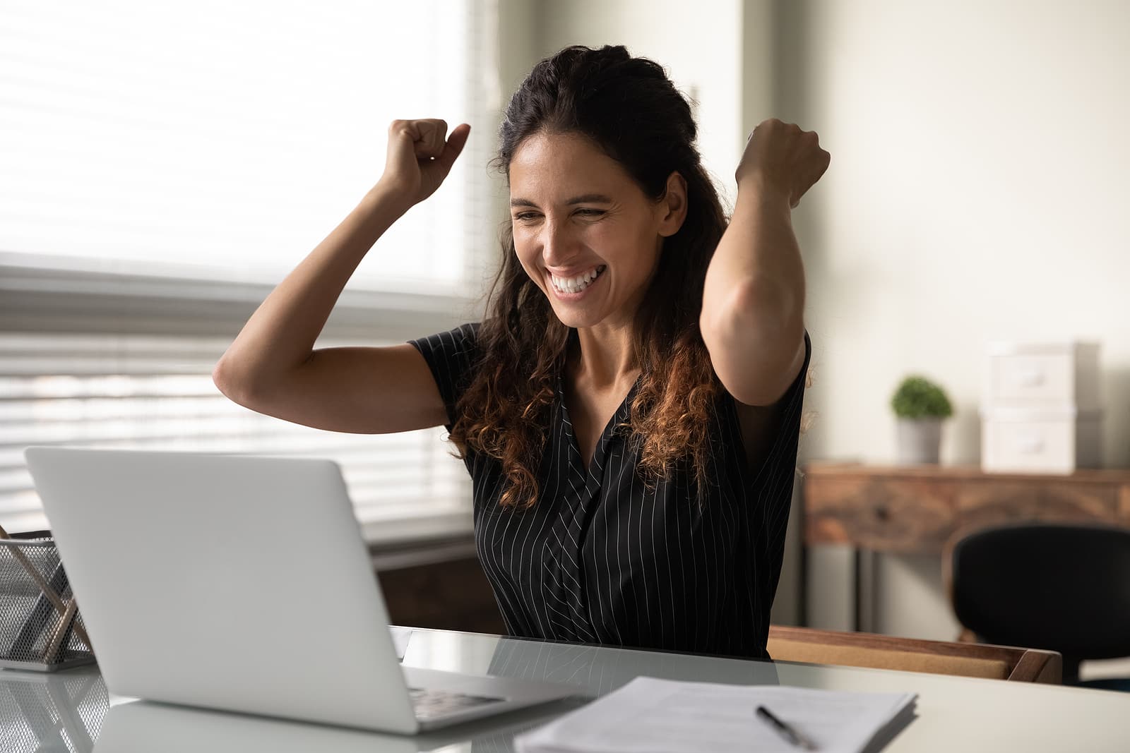Happy excited millennial businesswoman in casual excited with good news