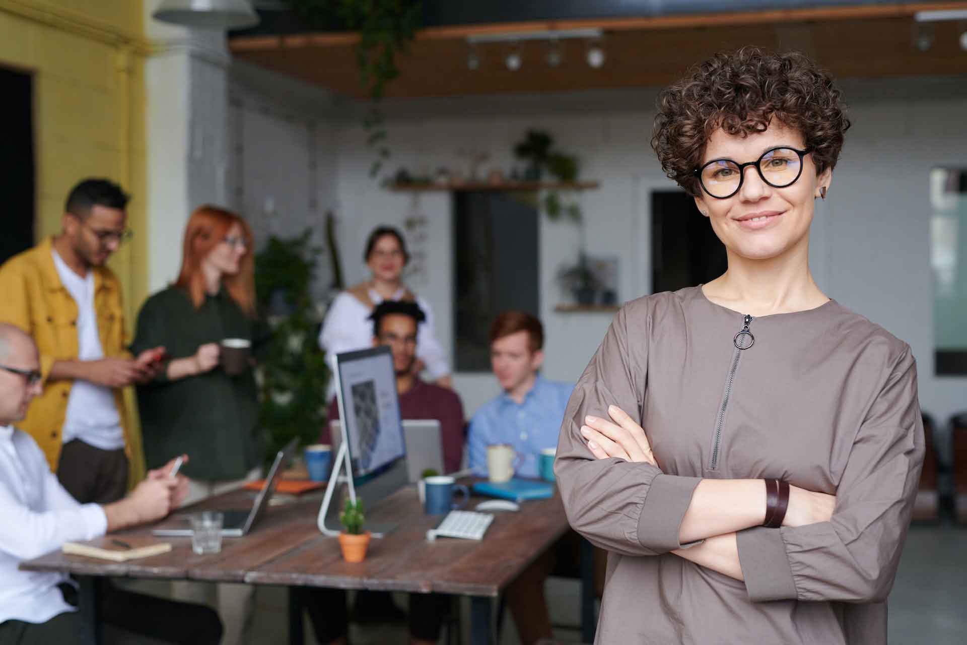 green business owner smiling with a group of people behind her