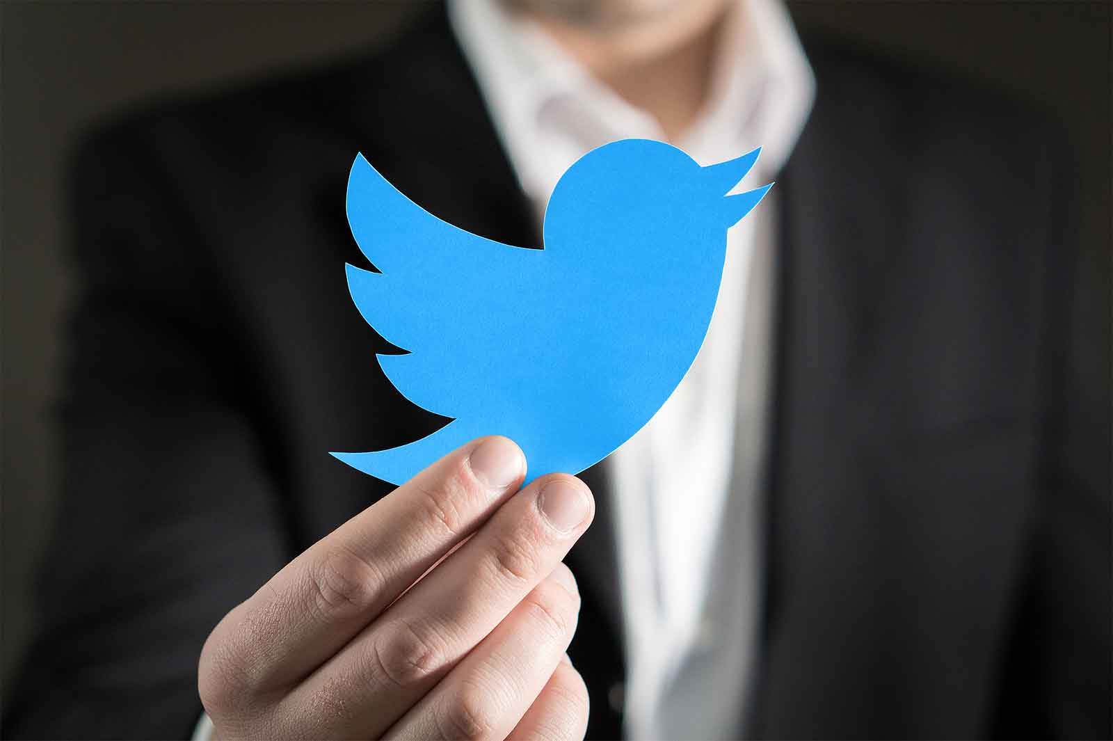 man holding twitter logo bird