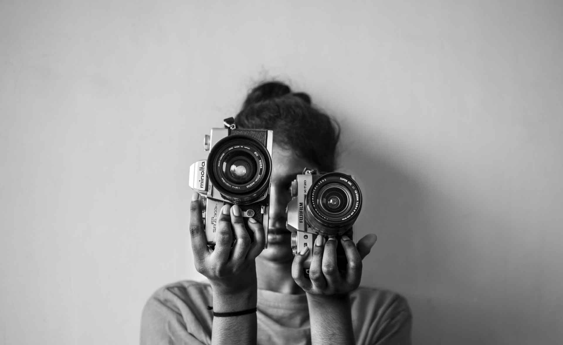 grayscale_photo_of_woman_holding_camera